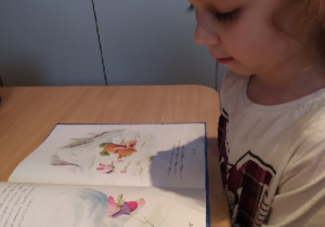 Dziewczynka ogląda obrazki w książce